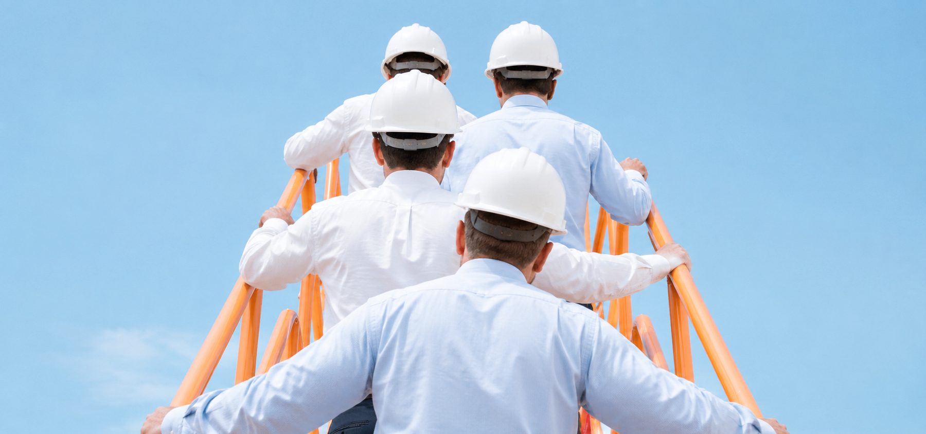 A team in hard hats climbing a ladder, seen from behind, under a blue sky